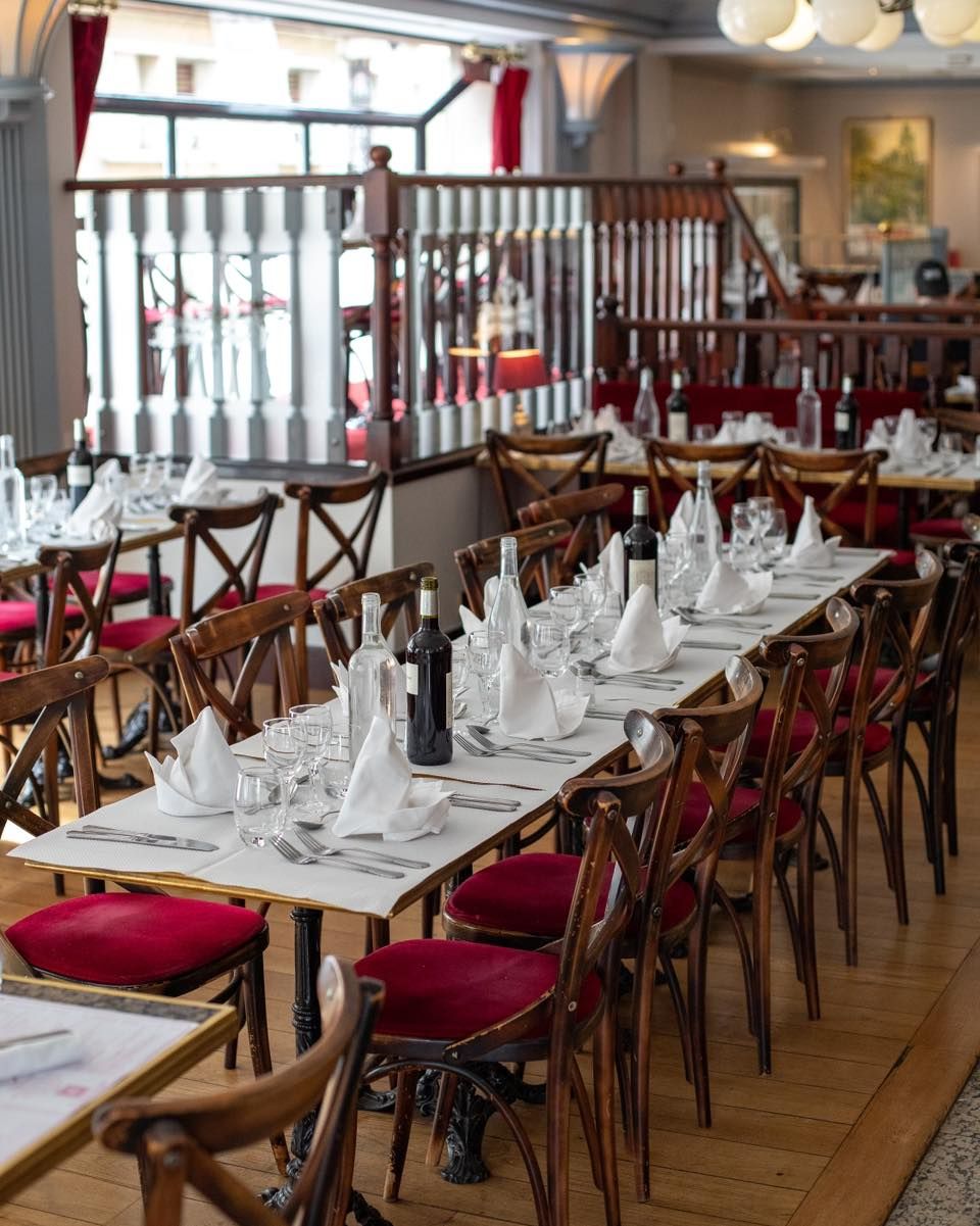 Les grandes tables nappées de la Brasserie Paul prêtes à recevoir un banquet